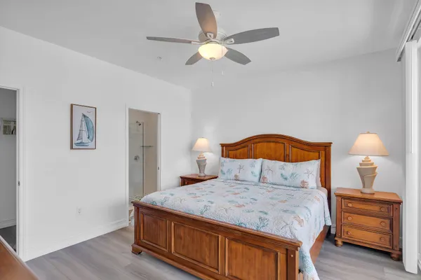 a bedroom with a bed and a dresser with wooden floor