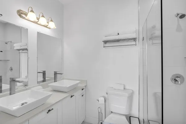 a bathroom with a sink vanity mirror and toilet