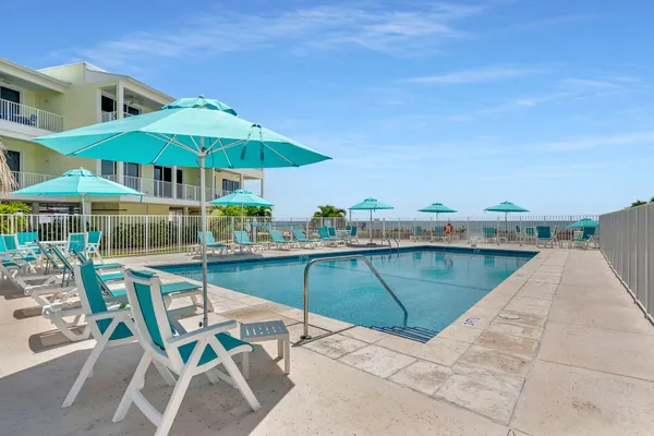 a view of a swimming pool with chairs in patio