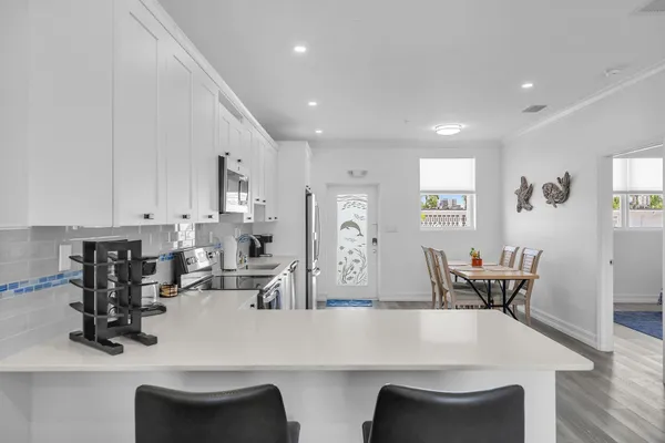 a view of kitchen with dining table chairs and wooden floor