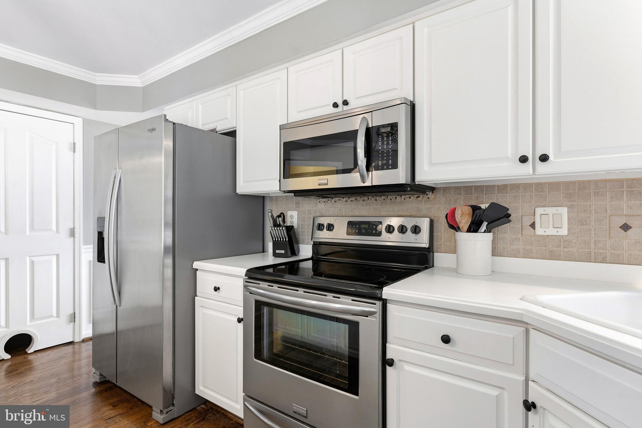 9 Penny Lane Perryville, MD 21903 - Photo 14 of 33 a kitchen with stainless steel appliances granite countertop white cabinets and a stove a refrigerator with wooden floor