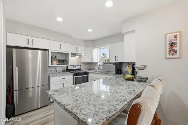 a kitchen with stainless steel appliances granite countertop a sink refrigerator and microwave
