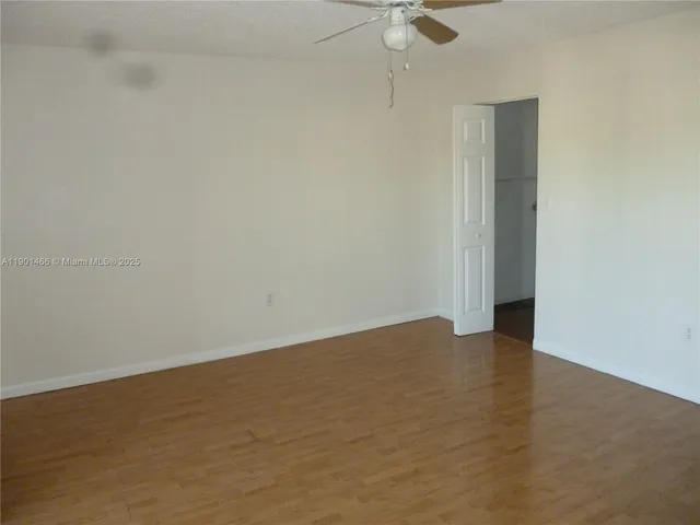 an empty room with a empty space and a ceiling fan