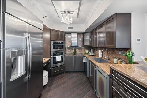 a kitchen with granite countertop stainless steel appliances cabinets a sink and a counter top space