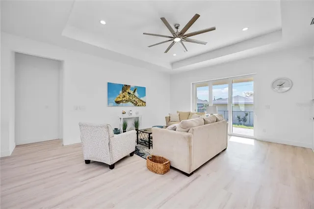 a living room with furniture kitchen area and a chandelier