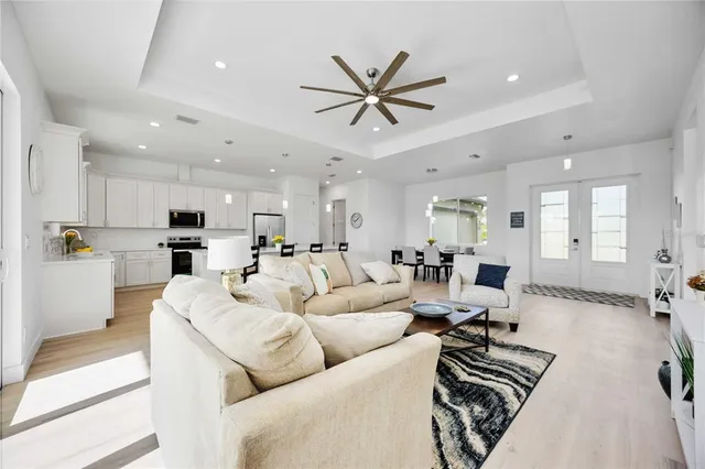 a kitchen with stainless steel appliances a dining table chairs refrigerator and microwave