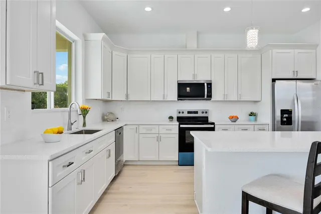 a large kitchen with stainless steel appliances lots of counter space and white cabinets