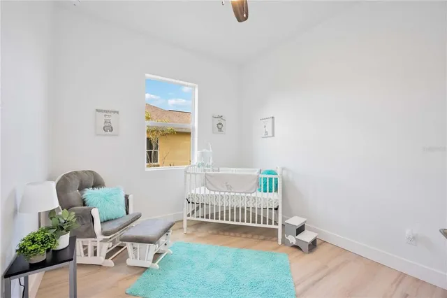 a bedroom with a large bed a painting on the wall and a dresser