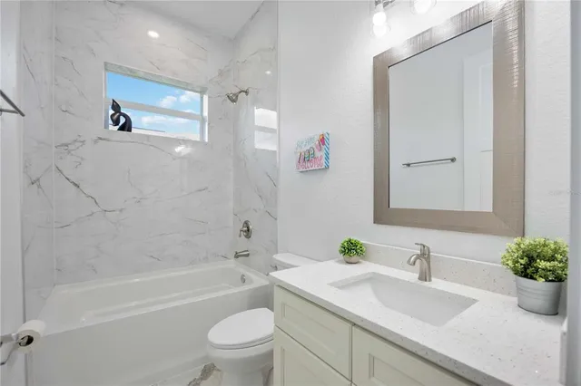 a bathroom with a tub sink and mirror