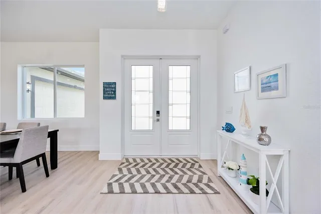 a living room with furniture kitchen view and a wooden floor