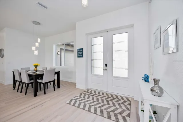 a living room with furniture and a dining table with wooden floor