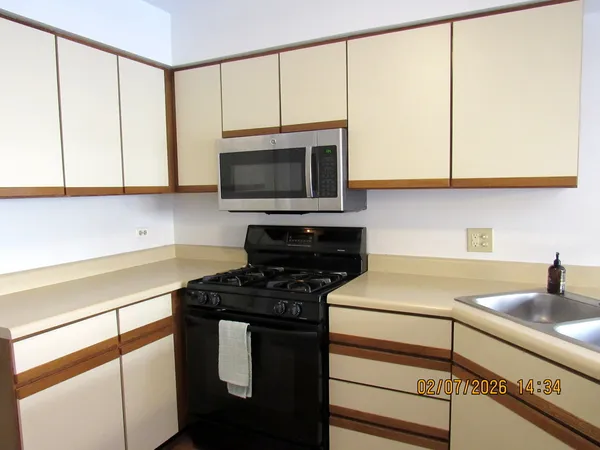 a kitchen with stainless steel appliances a sink a stove cabinets and a microwave