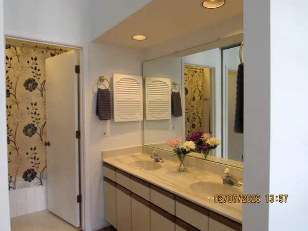 a bathroom with a granite countertop sink a mirror and shower