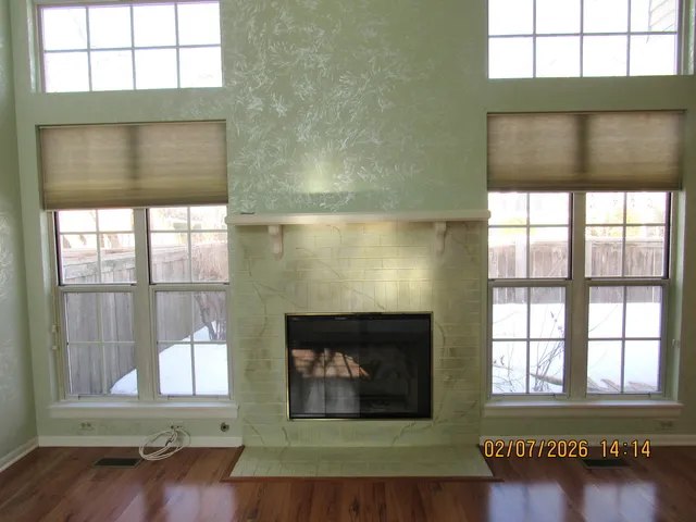 a view of an empty room with wooden floor and a floor to ceiling window