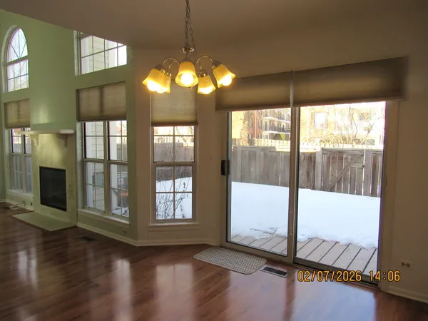 a view of an empty room with wooden floor and a floor to ceiling window