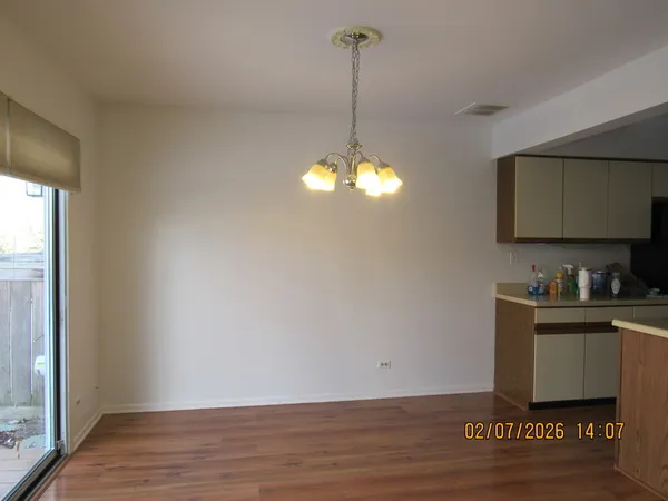 a room with kitchen island granite countertop wooden floors a sink and a stove
