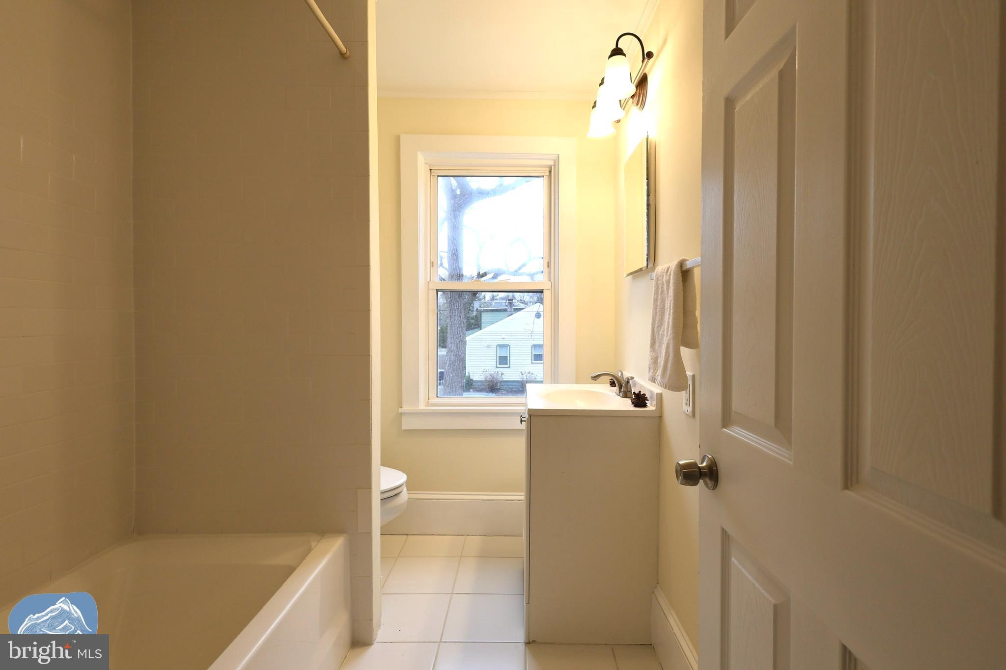 401 2nd Street Riverton, NJ 08077 - Photo 25 of 39 a bathroom with a tub a sink and a window