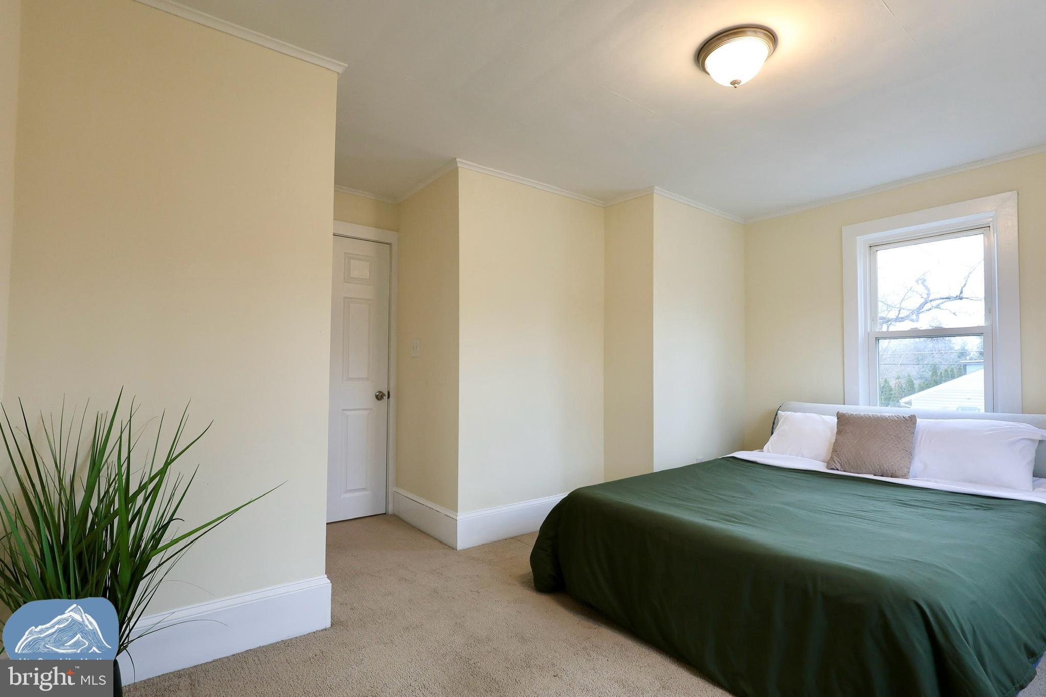 401 2nd Street Riverton, NJ 08077 - Photo 31 of 39 a bedroom with a bed and a potted plant