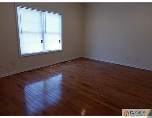 529 New Durham Road Piscataway, NJ 08854 - Photo 18 of 25 an empty room with wooden floor and windows