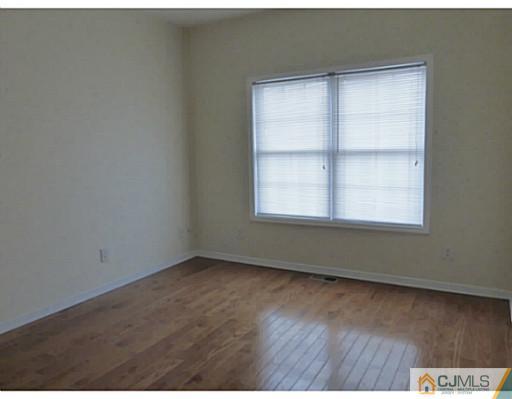 529 New Durham Road Piscataway, NJ 08854 - Photo 20 of 25 an empty room with wooden floor and windows