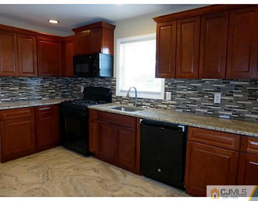 529 New Durham Road Piscataway, NJ 08854 - Photo 4 of 25 a kitchen with stainless steel appliances granite countertop wooden cabinets a stove top oven a sink and dishwasher