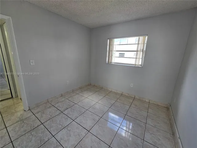 a view of a hallway with wooden floor and windows