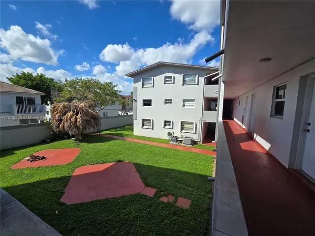 a kitchen with granite countertop a stove a sink and a refrigerator