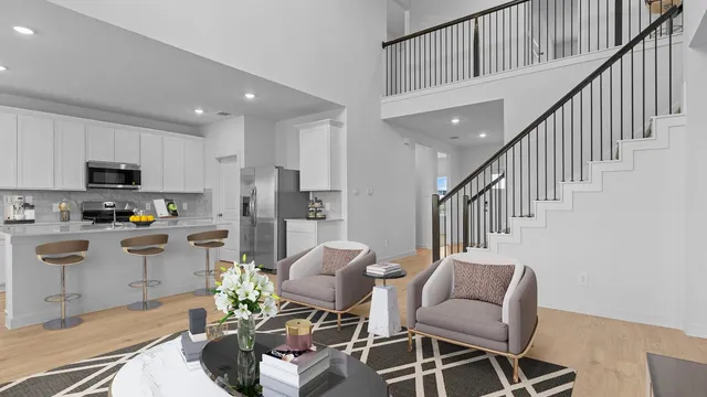 a kitchen with stainless steel appliances kitchen island granite countertop a dining table chairs and a refrigerator