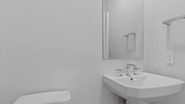 a bathroom with a toilet a sink and mirror