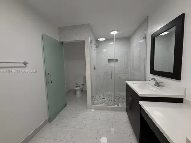 a bathroom with a sink a toilet and shower