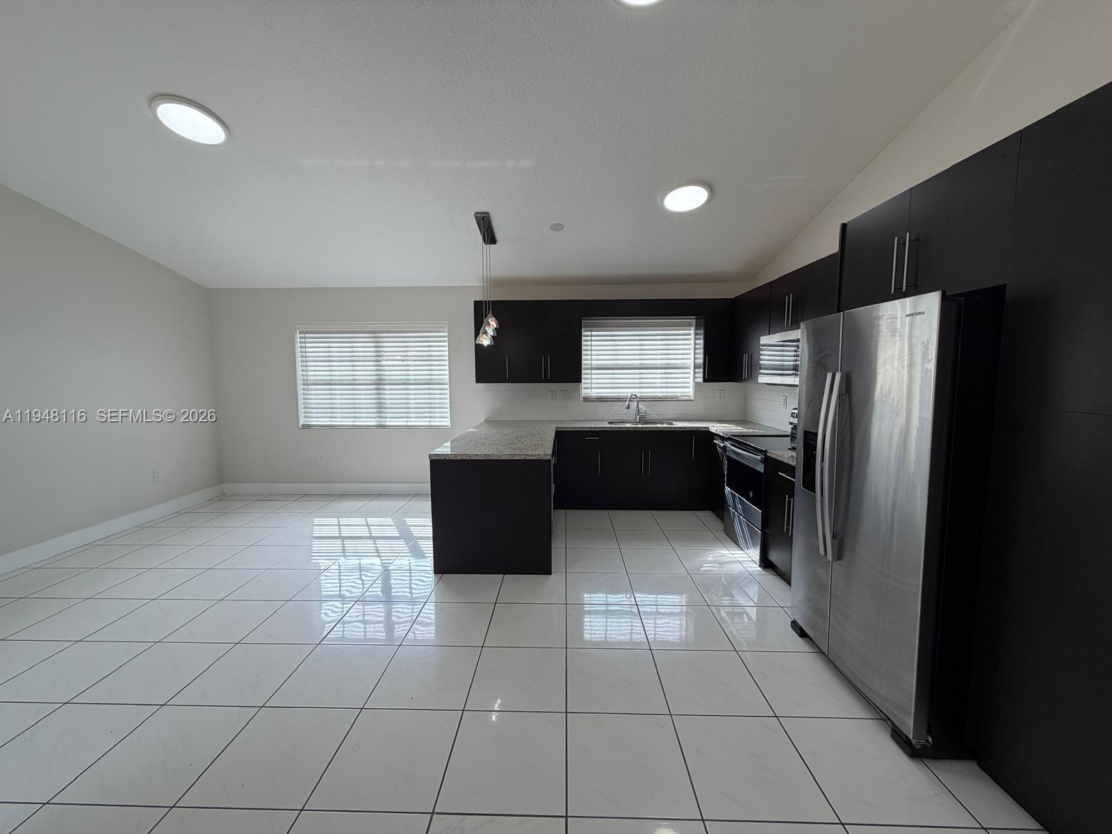 9125 Southwest 166th Avenue Miami, FL 33196 - Photo 7 of 25 a kitchen with stainless steel appliances granite countertop a refrigerator and a stove top oven