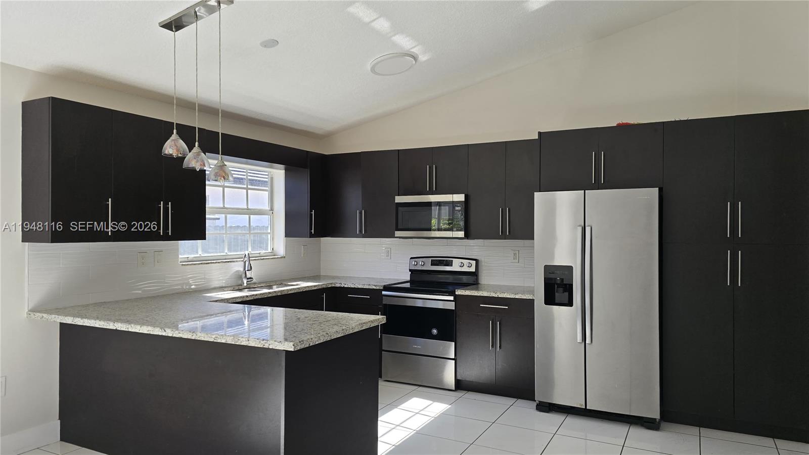 9125 Southwest 166th Avenue Miami, FL 33196 - Photo 8 of 25 a kitchen with a refrigerator a sink a stove a microwave and wooden cabinets