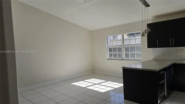 a kitchen with granite countertop white cabinets and black appliances