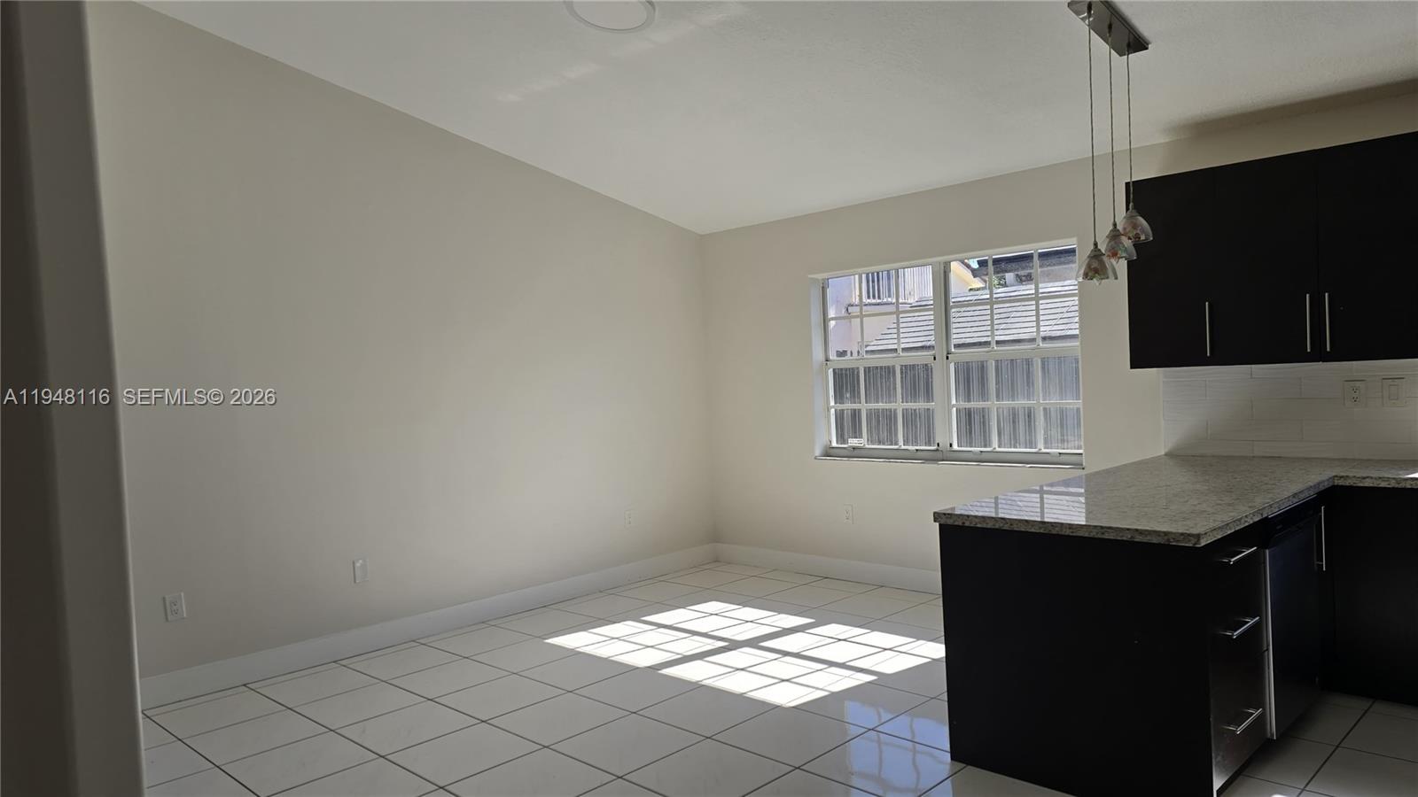 9125 Southwest 166th Avenue Miami, FL 33196 - Photo 9 of 25 a kitchen with granite countertop white cabinets and black appliances