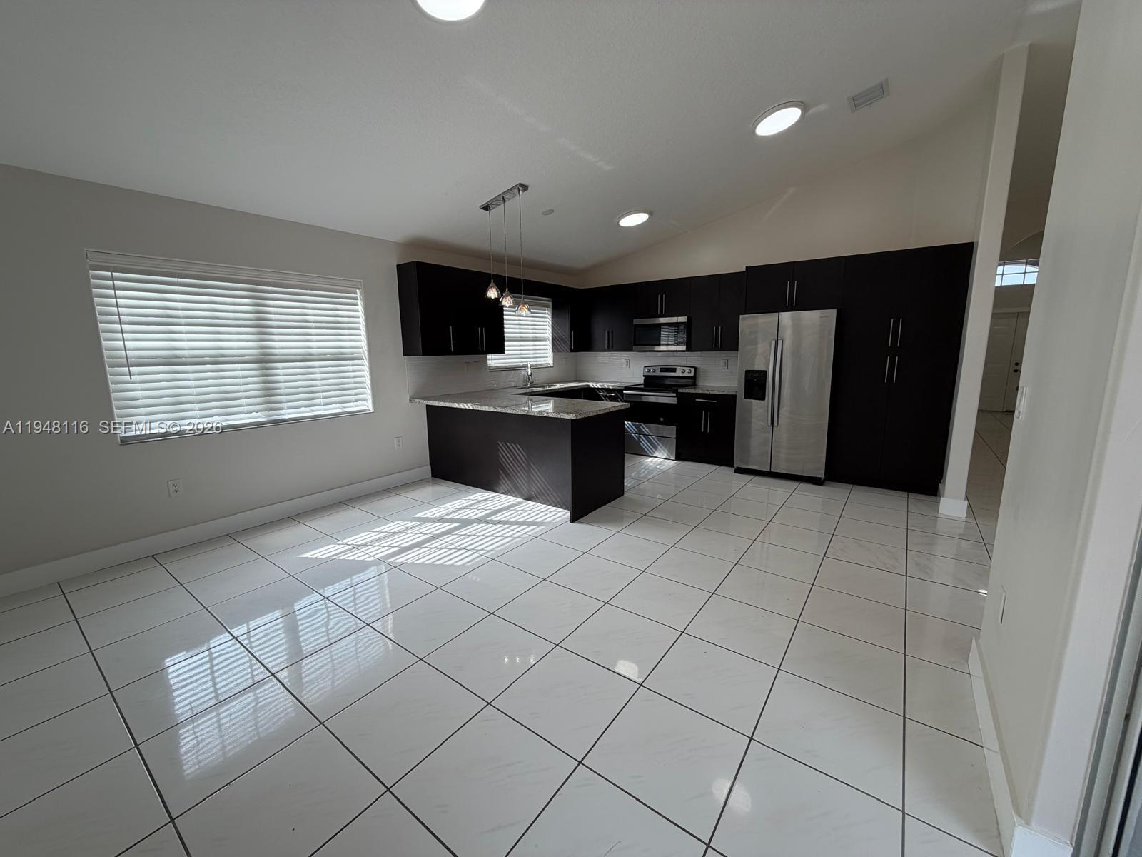 9125 Southwest 166th Avenue Miami, FL 33196 - Photo 10 of 25 a large white kitchen with a stove a refrigerator and a sink