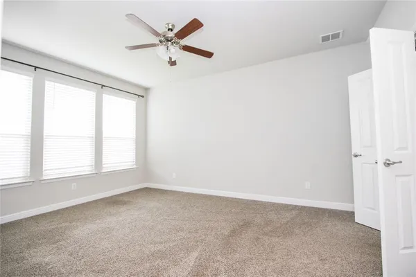 an empty room with a window and a ceiling fan