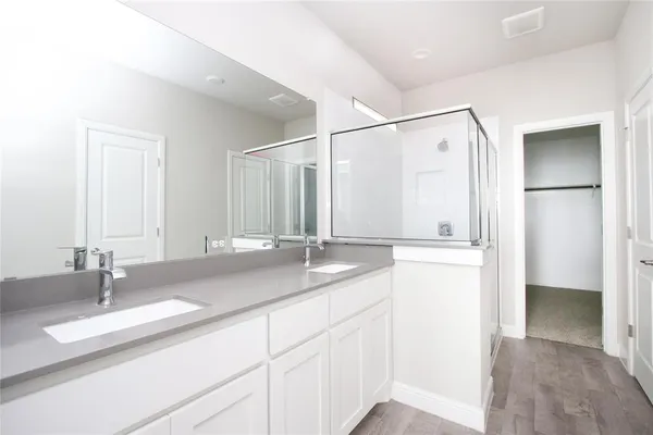 a bathroom with double vanity sinks and a shower
