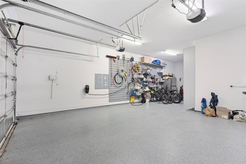 15018 Crape Myrtle Road Frisco, TX 75035 - Photo 23 of 40 Spacious garage featuring a durable epoxy floor, integrated overhead lighting, and an electric vehicle charging station