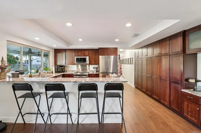 a kitchen with stainless steel appliances granite countertop a stove a sink and a refrigerator