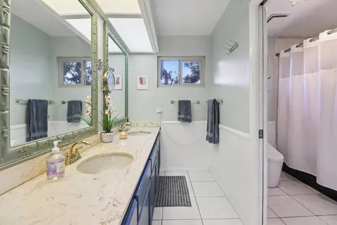 a bathroom with a granite countertop sink a toilet and shower