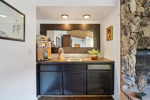 a dining room with wooden floor a chandelier a glass table and chairs