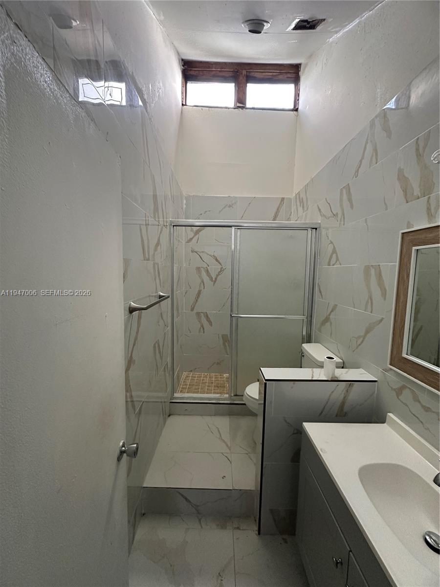 6824 Southwest 37th Street, Unit 6E Miramar, FL 33023 - Photo 5 of 9 a bathroom with a sink a toilet and shower