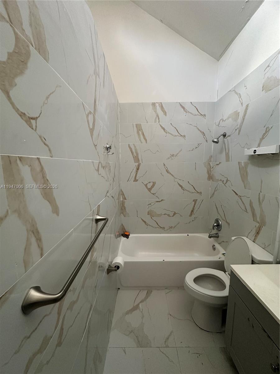 6824 Southwest 37th Street, Unit 6E Miramar, FL 33023 - Photo 6 of 9 a bathroom with a toilet a sink and bathtub