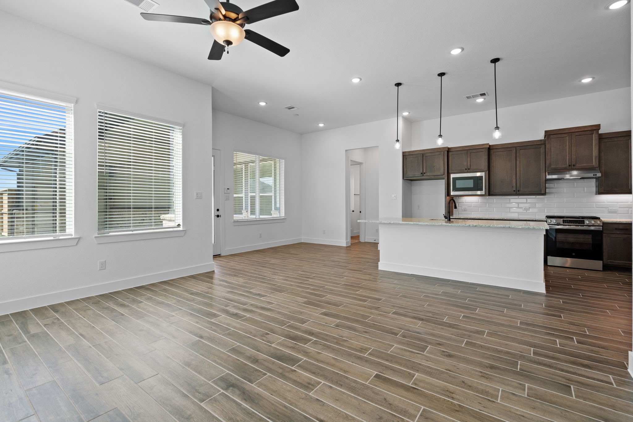 12002 Rice View Drive Mont Belvieu, TX 77523 - Photo 16 of 50 a view of kitchen with stainless steel appliances granite countertop a stove top oven a sink dishwasher a refrigerator and white cabinets with wooden floor