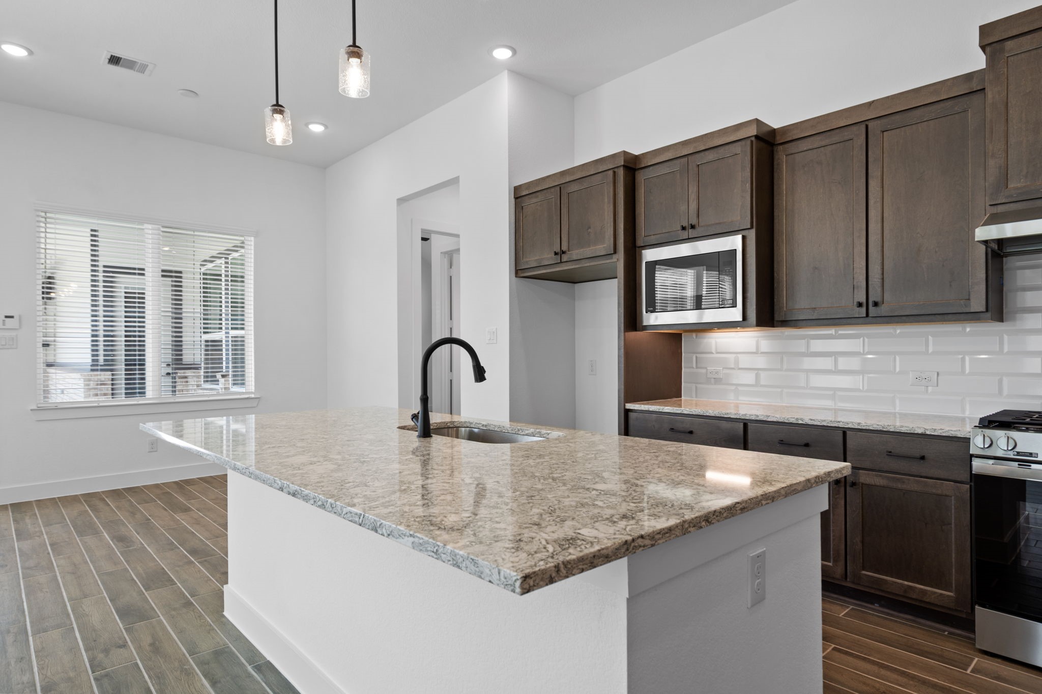 12002 Rice View Drive Mont Belvieu, TX 77523 - Photo 10 of 50 a kitchen with stainless steel appliances granite countertop a sink a microwave counter space and cabinets