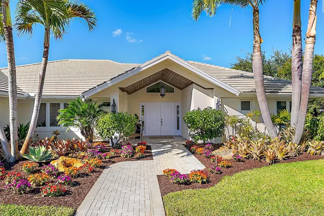 a front view of a house with a yard and potted plants