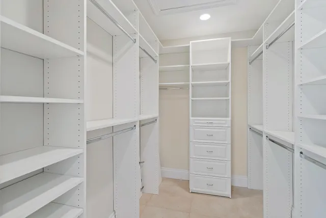 a bed sitting in a bedroom next to a window and a chair