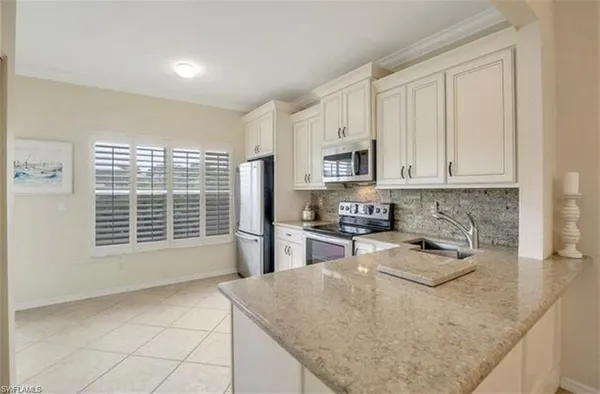 a kitchen with stainless steel appliances granite countertop a sink stove and white cabinets