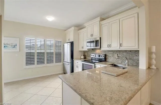 a kitchen with stainless steel appliances granite countertop a sink stove and white cabinets