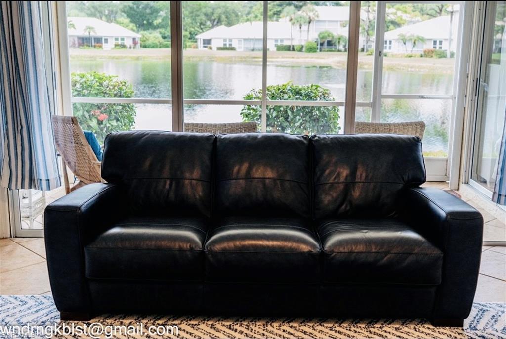 298 Emerald Bay Circle, Unit K6 Naples, FL 34110 - Photo 5 of 9 a living room with furniture and a large window